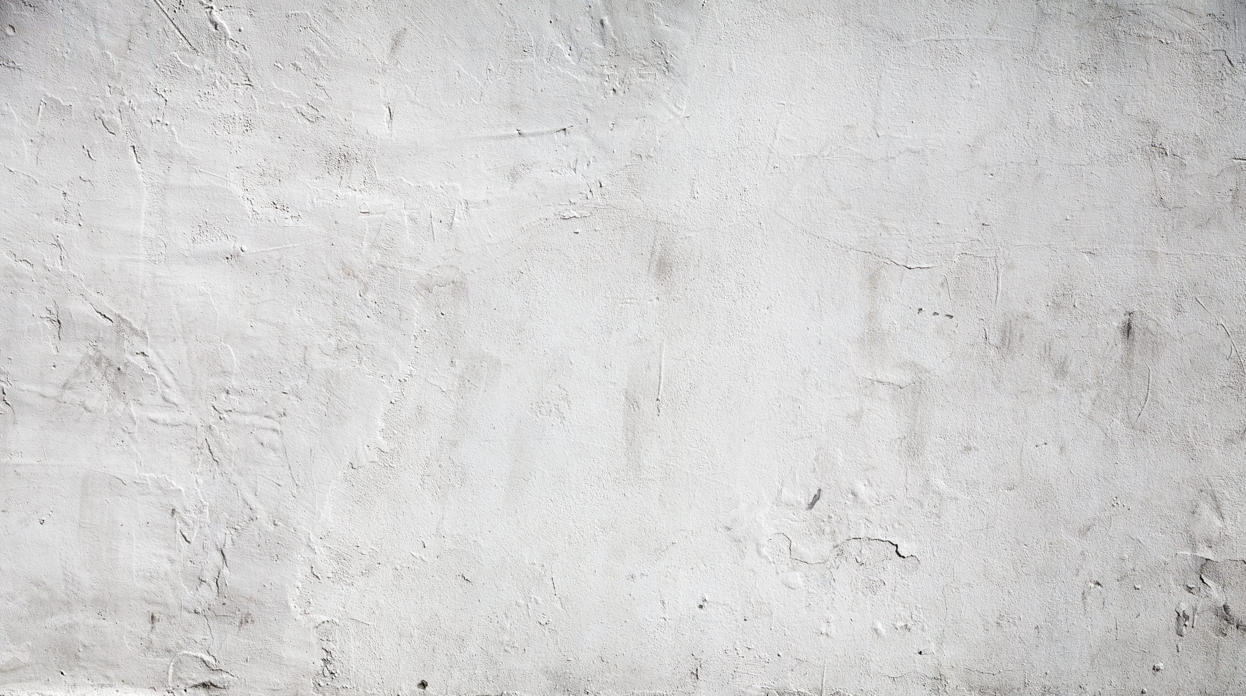White concrete wall background texture with plaster Rough, white plaster wall with visible texture and subtle cracks and marks, highlighting the character of aged plaster wall surfaces.